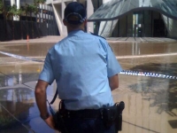 A police officer monitors water outside Riparion Plaza