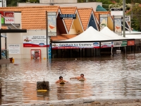 Surfers paddle through Rosalie\'s Nash St.